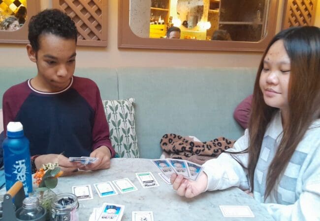 Photo of 2 people sitting playing a card game