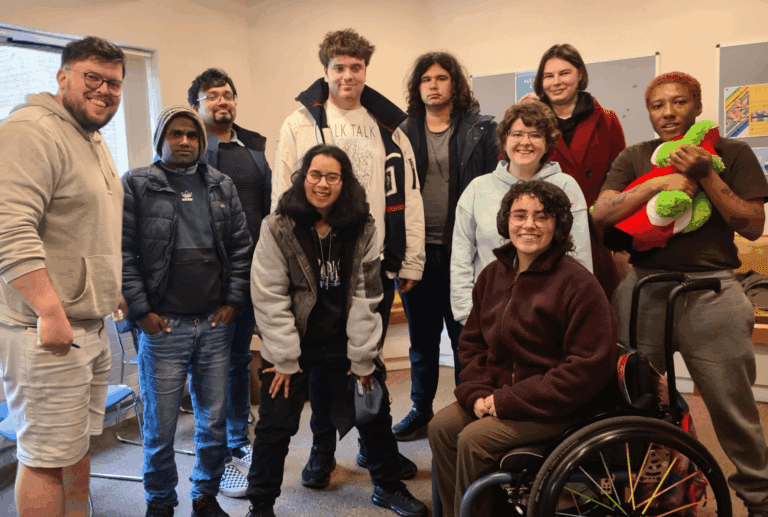 Group of 10 people, one in a wheelchair, who are part of RAID's Neurodiverse community.