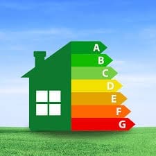 A green house icon with labels A to G on coloured bars, representing Energy efficiency ratings from most efficient (A, green) to least efficient (G, red), on a grassy field with a blue sky background.